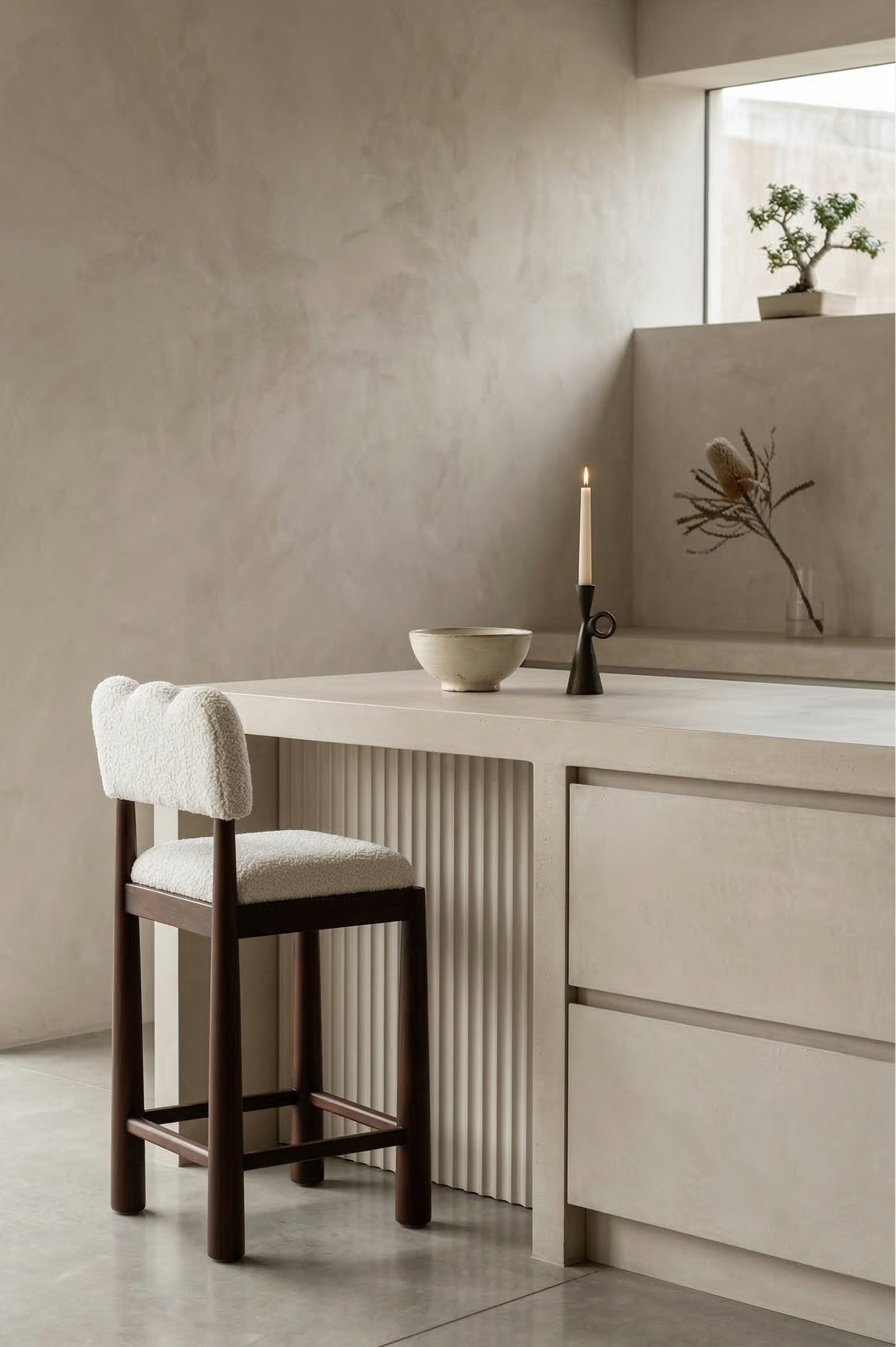 Modern kitchen with a bar stool, countertop, and decorative elements.