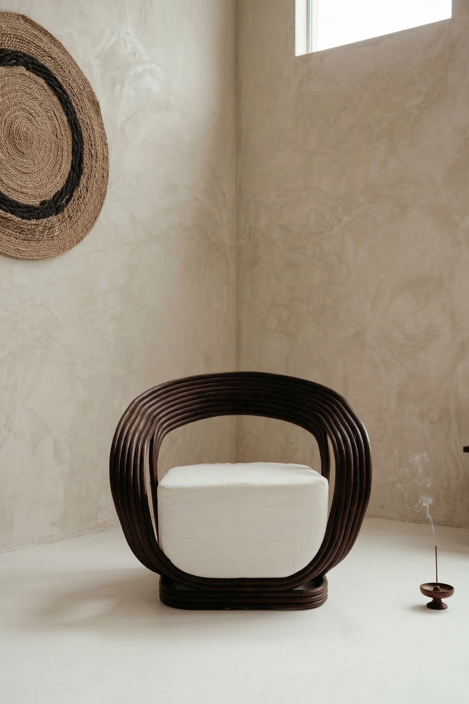 Modern chair with white cushion in a minimalistic room with textured walls and a woven wall art piece.