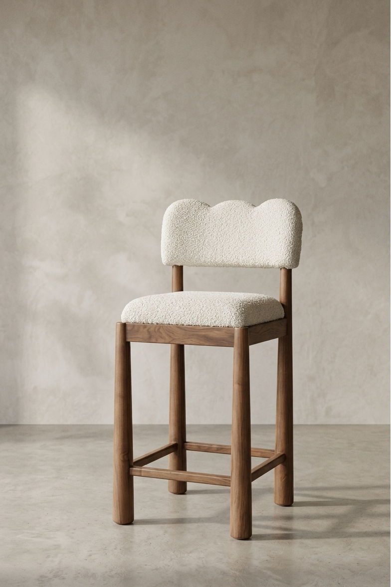 Wooden bar stool with white cushioned seat and backrest against a beige wall.