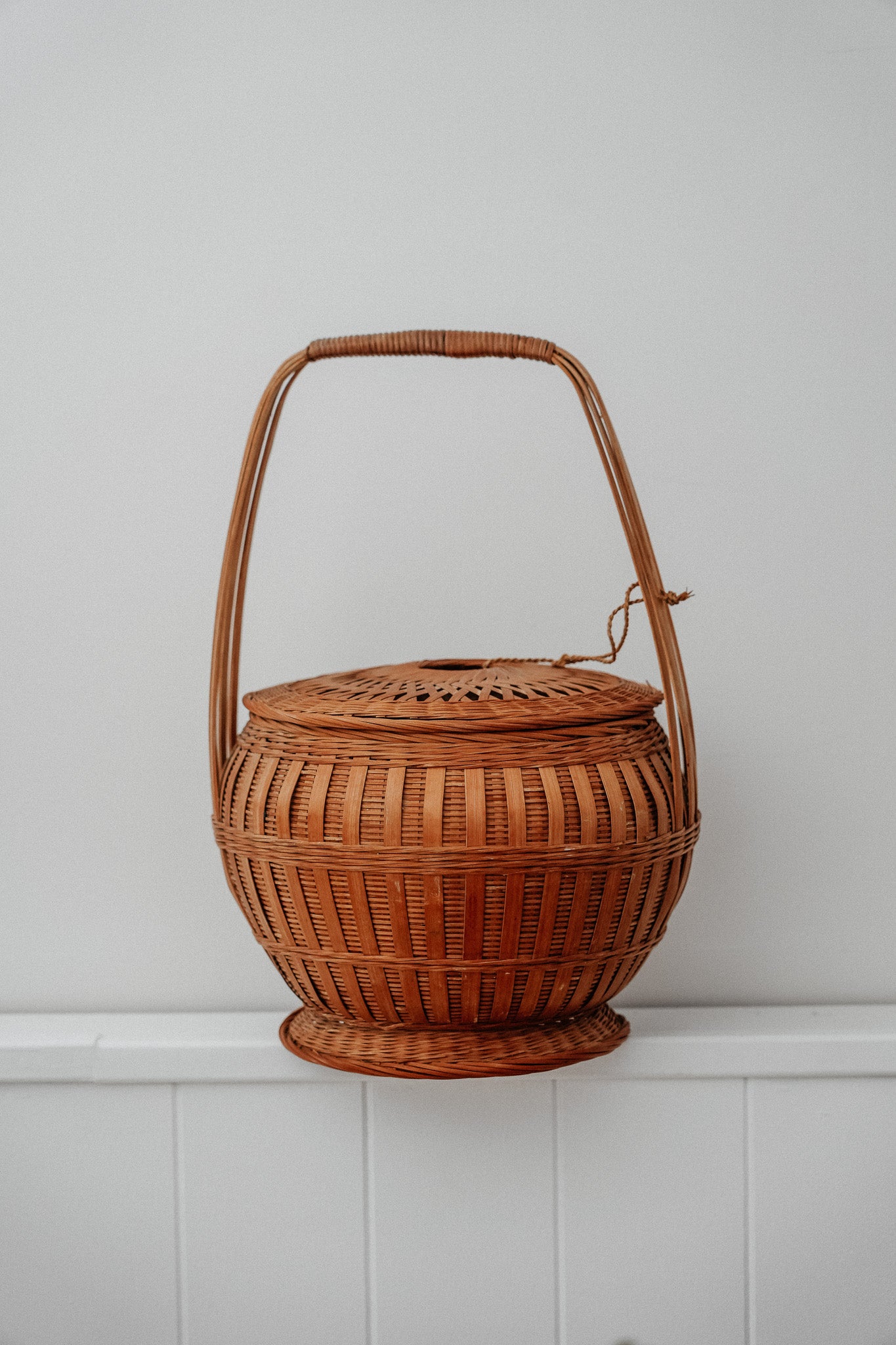 Woven basket with tie on lid