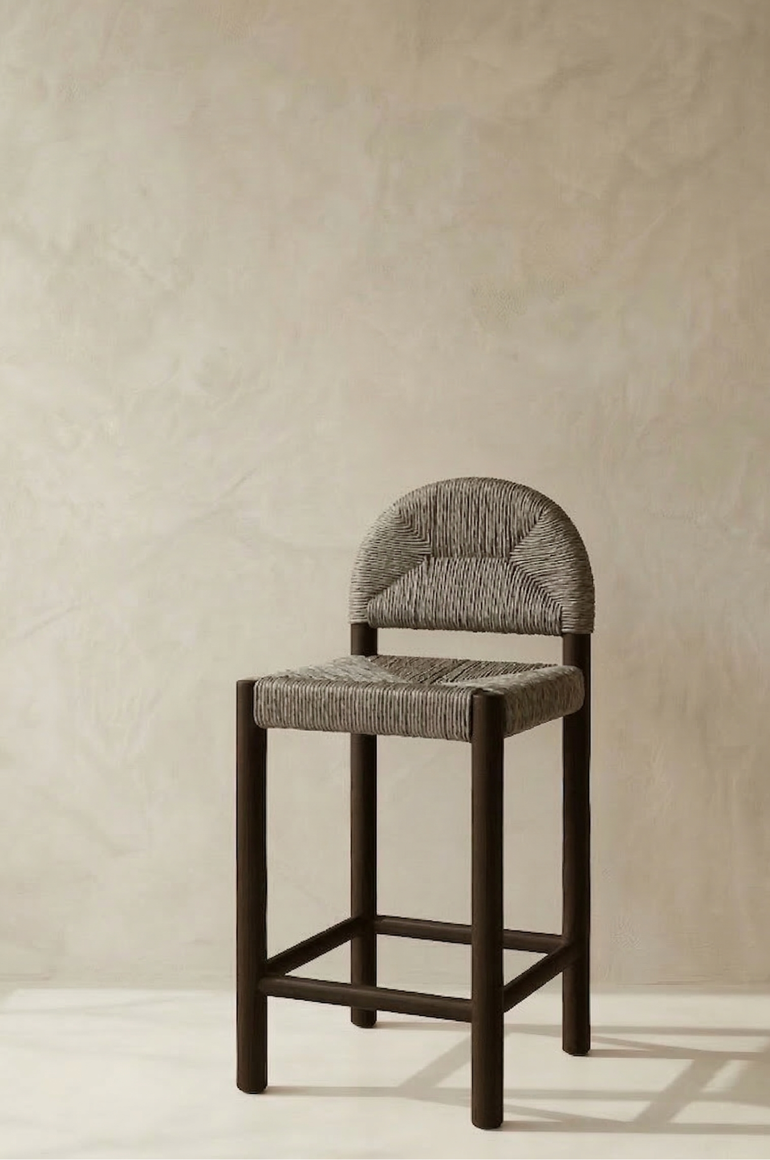 Bar stool with textured backrest and seat against a beige wall