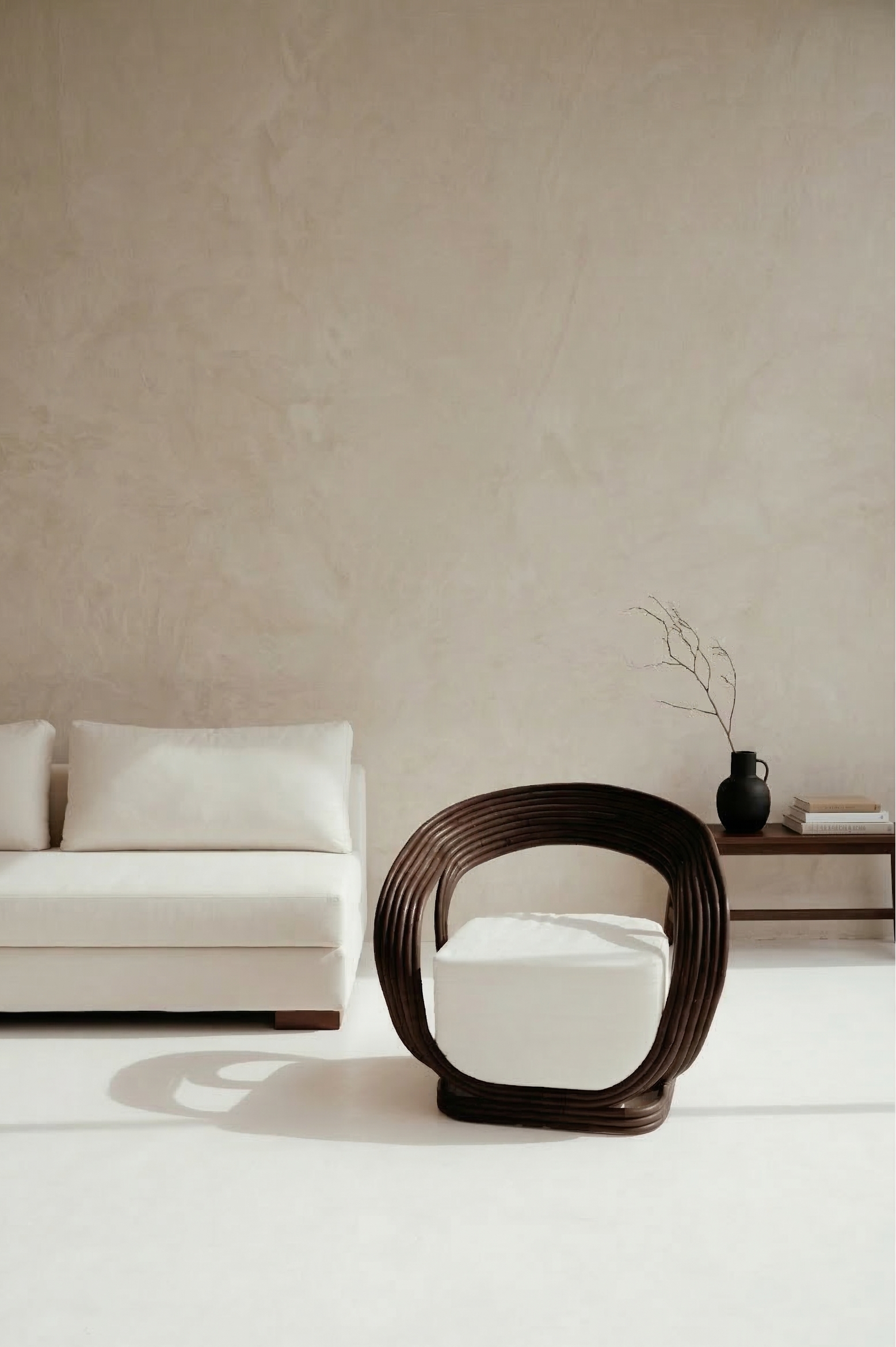 Modern white sofa and chair against a beige wall with minimal decor.